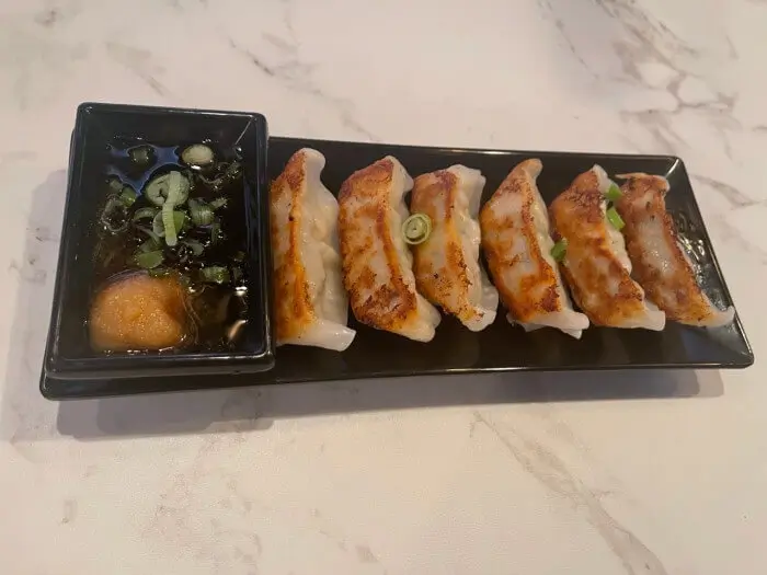 Pan-Fried Gyoza - Six pieces of crispy - on - the - outside, tender - on - the - inside pan - fried dumplings with dipping sauce at Ramen Jin, a Ramen restaurant in Houston