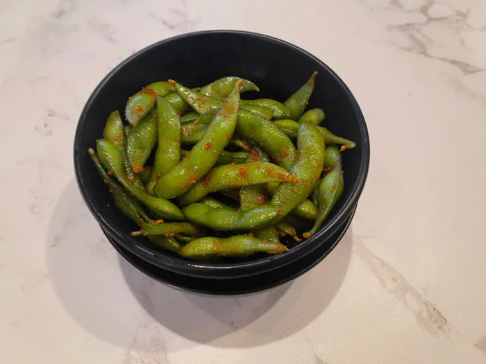 Spicy Edamame - Boiled edamame beans seasoned with spicy spices, served in a bowl at Ramen Jin, a Ramen restaurant in Houston